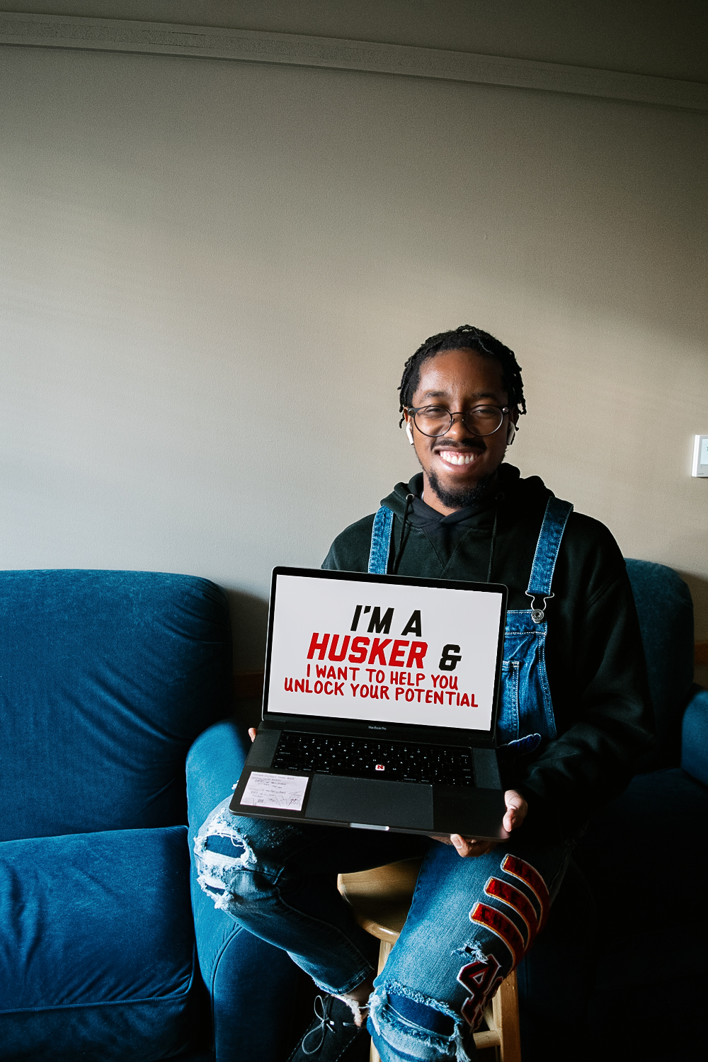 Eric holding a sign that says "I'm a Husker and I want to help you unlock your potential."