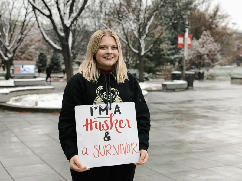 Student holding sign with I am a Husker language