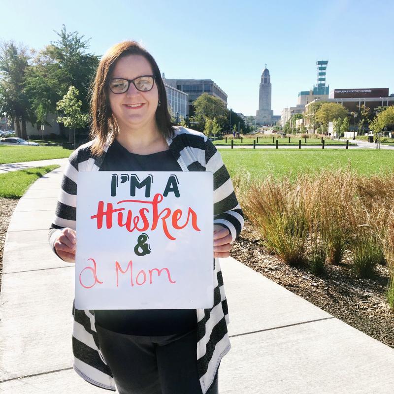 Student holding sign with I am a Husker language