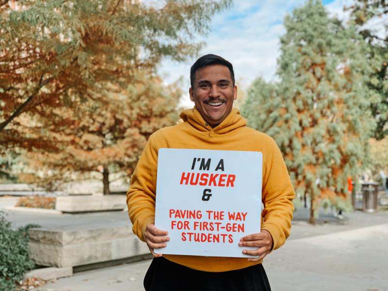 Anibal smiles for a photo with a sign that reads “I’m a Husker & paving the way for first-gen students”