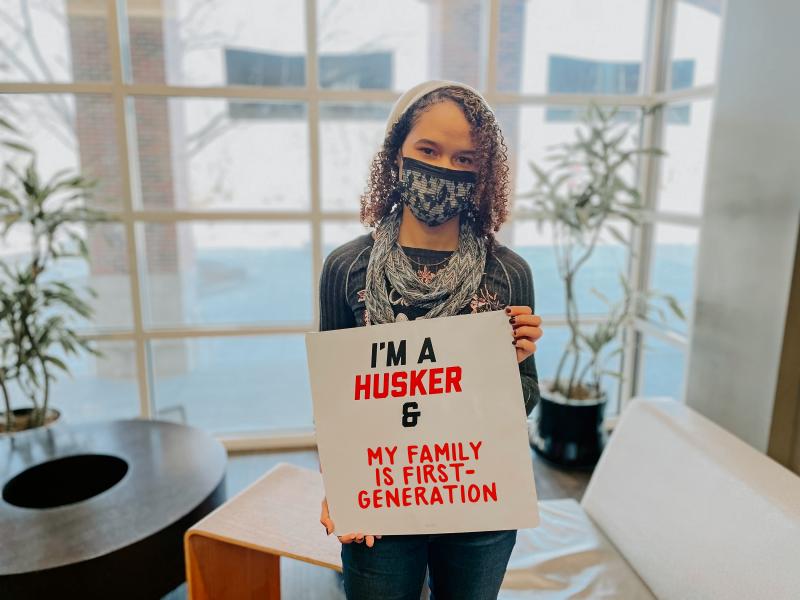 Nayla holds a sign that says "I'm a Husker & my family is first-generation"