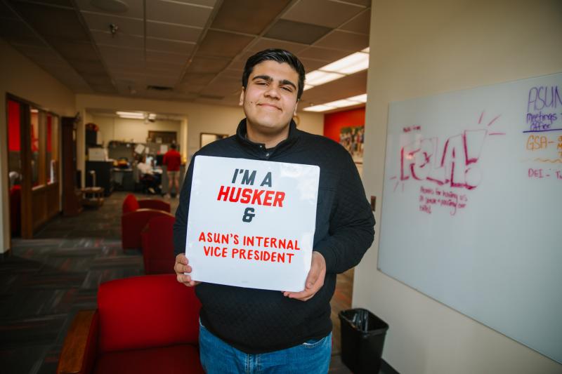 Zein smiles for a photo with a sign that says "I'm a Husker & ASUN's internal vice president"
