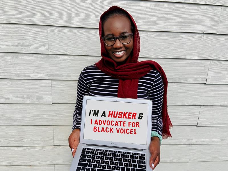 Aiah holding a sign that says "I'm a Husker and I advocate for Black voices."